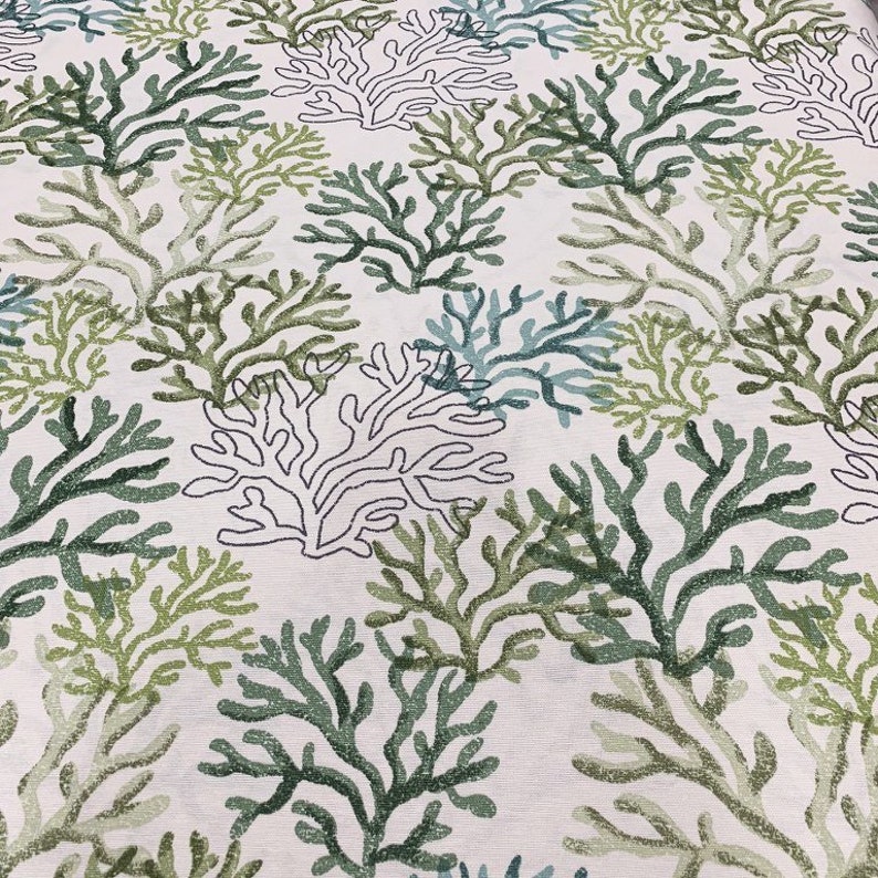 Puede incluir: Una tela blanca con un patr&oacute;n repetitivo de coral verde y azul. El coral est&aacute; delineado en negro.