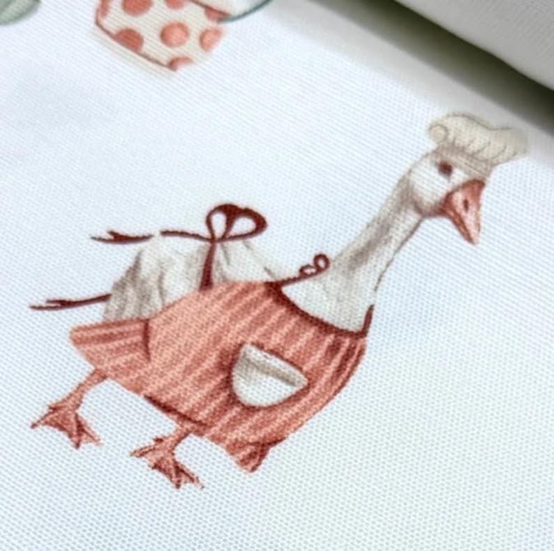 May include: A white goose wearing a pink and white striped apron and a white chef's hat. The goose is standing on a white background.