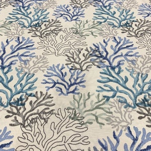 Puede incluir: Una tela blanca con un patr&oacute;n repetitivo de coral azul, gris y verde. El coral est&aacute; delineado en negro.