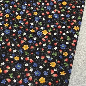 May include: Black fabric with a repeating pattern of small red, blue, yellow, and white flowers.