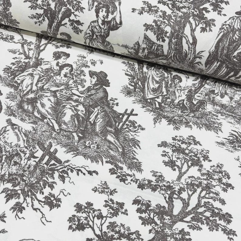 May include: White fabric featuring a dark brown toile de Jouy pattern. The design shows scenes of people in a rural setting, with figures, trees, and buildings. The fabric is folded, revealing the pattern's repetition.