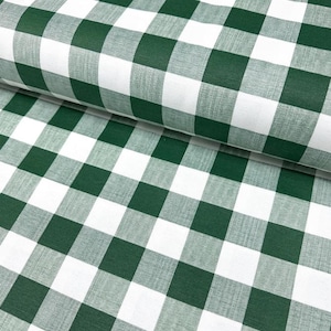 Könnte beinhalten: Nahaufnahme eines grün-weiß karierten Stoffes. Der Stoff ist gefaltet und zeigt das sich wiederholende Muster großer Quadrate. Das Material scheint mittelschweres Baumwoll- oder ähnliches Mischgewebe zu sein. Das klassische Karomuster ist deutlich sichtbar.