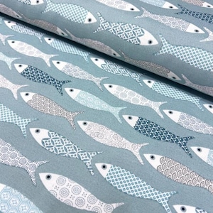 May include: A fabric with a repeating pattern of stylized fish in shades of blue, gray, and white. The fish have patterned scales and are arranged diagonally across a light blue background. The fabric is likely used for home decor or apparel.