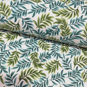 May include: White fabric with a repeating pattern of green and teal leaves. The leaves are detailed with visible veins and are arranged in a dense, overlapping design. The fabric has a slight sheen.