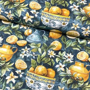 May include: A teal blue fabric with a repeating pattern of lemons, white flowers, and green leaves. The pattern also includes yellow ceramic jugs and bowls filled with lemons.