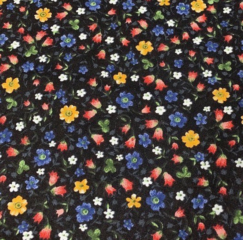 May include: Black fabric with a repeating pattern of small red, yellow, blue, and white flowers.