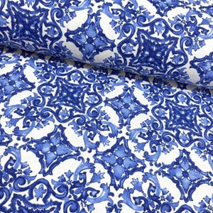 Könnte beinhalten: Weißer Stoff mit einem sich wiederholenden Muster aus blauen und weißen, komplizierten Fliesenmustern. Das Muster erinnert an traditionelle portugiesische Fliesen.