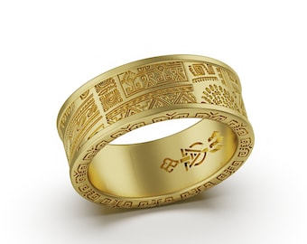 Op de afbeelding: Een gouden ring met een gedetailleerd geometrisch patroon rond de band. De ring is gemaakt van glad, gepolijst metaal en heeft een subtiele glans.