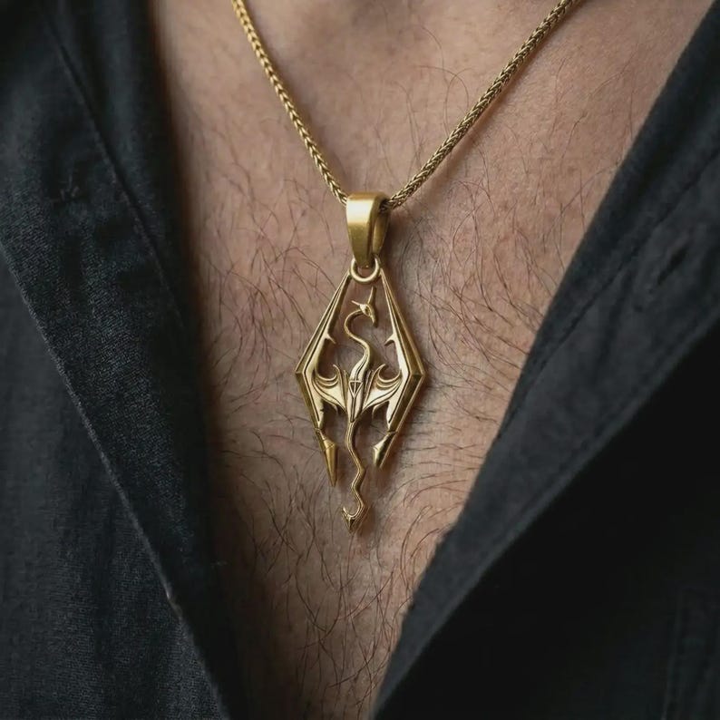 Gold plated Skyrim dragon pendant necklace worn on the chest, premium lifestyle jewelry photo with the fantasy dragon pendant centered on a spiga chain.