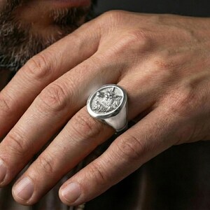 Polished silver wolf ring on hand, clean modern statement fit with sharp wolf profile detailing