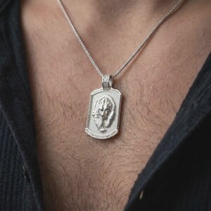 Polished silver grizzly bear and cub pendant worn on the chest, featuring sculpted wildlife details and a meaningful parent-child bond in a rugged dog tag necklace.