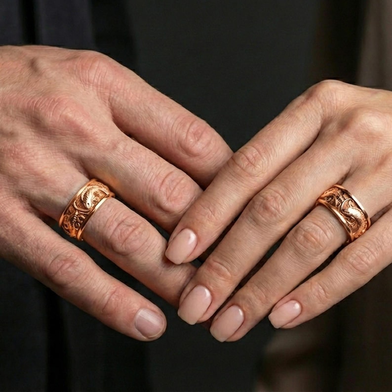 Rose gold plated dragon and koi fish ring worn on finger, detailed dragon and koi relief with textured background, elegant lifestyle wear shot.
