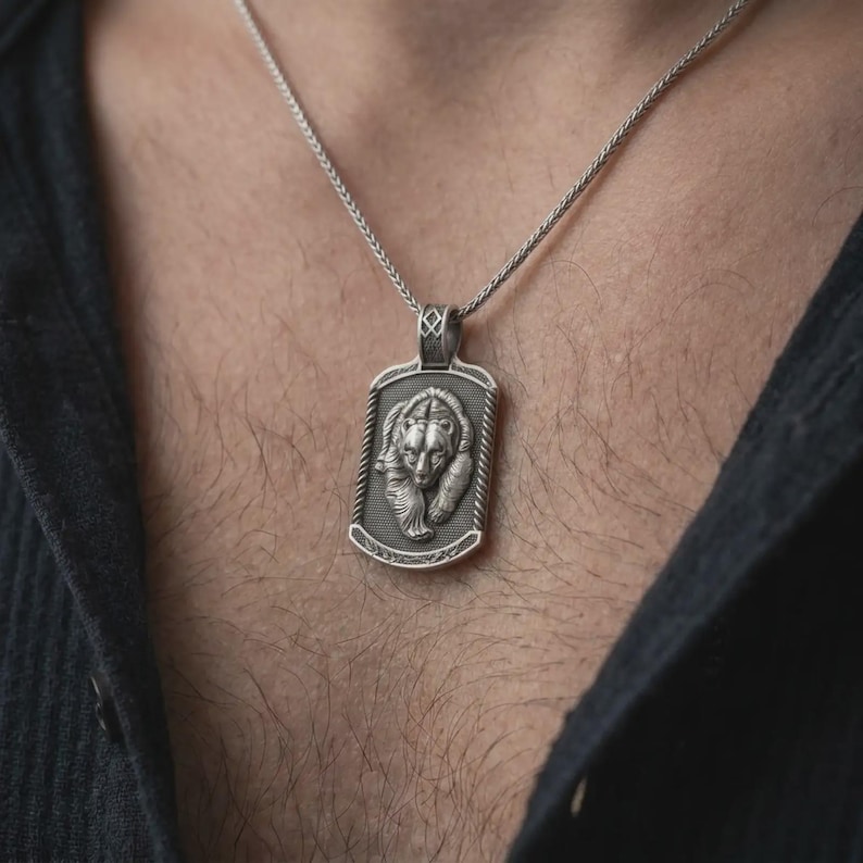 Oxidized sterling silver bear and cub necklace worn on the chest, showing the two detailed bear faces, textured dog tag medallion, and symbolic family protection design.
