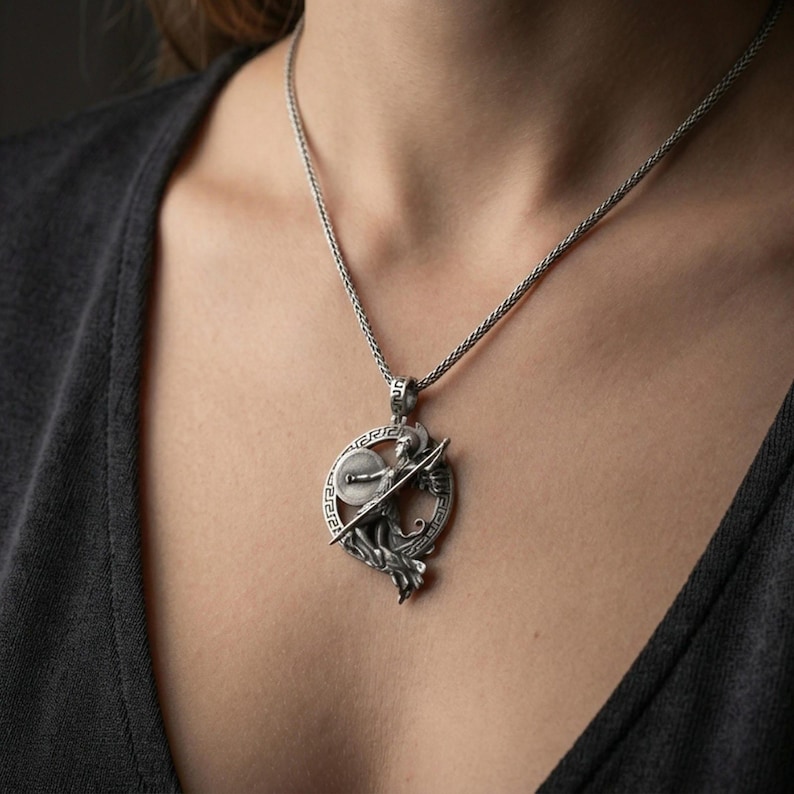 Oxidized Athena warrior pendant necklace worn on the neck, lifestyle framing showing realistic scale and bold vintage contrast against the chest.