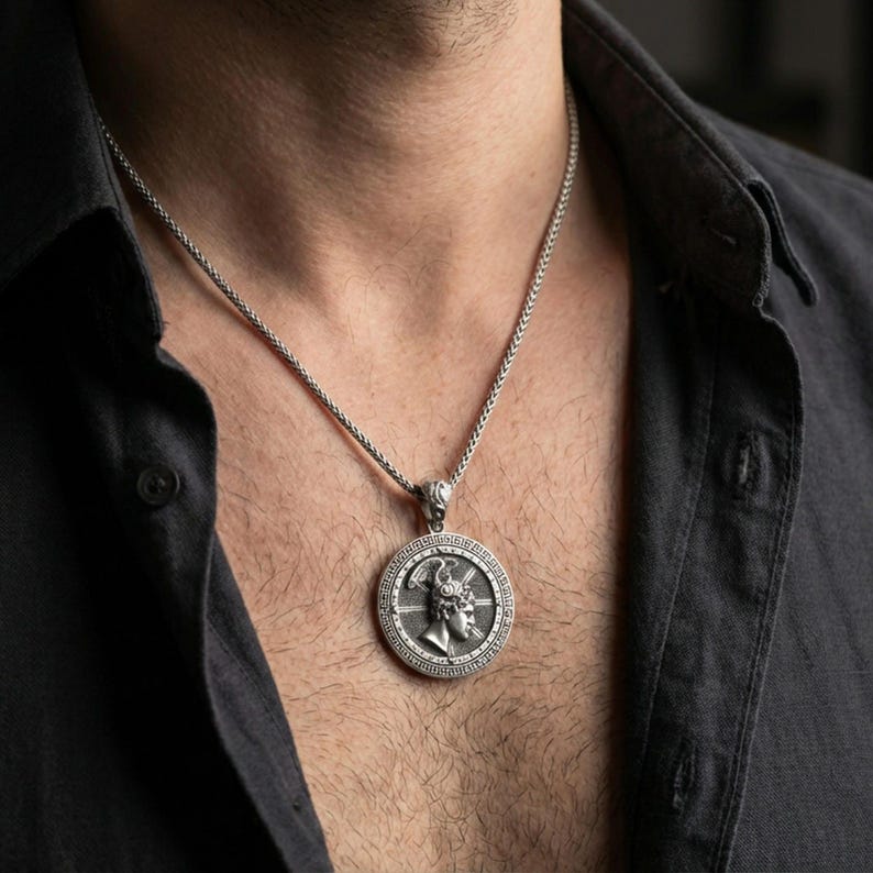 Oxidized Perseus coin pendant necklace worn on the neck, lifestyle framing showing realistic scale and bold vintage contrast against the chest.
