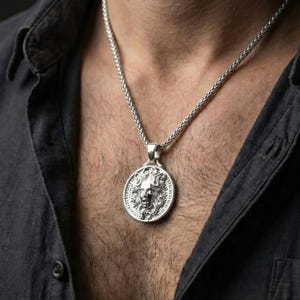 Polished silver Medusa amulet necklace worn on chest highlighting ancient Greek symbolism and strength