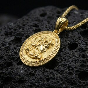 Gold plated Medusa coin pendant on volcanic rock, Greek key border medallion with classical Greek mythology face relief