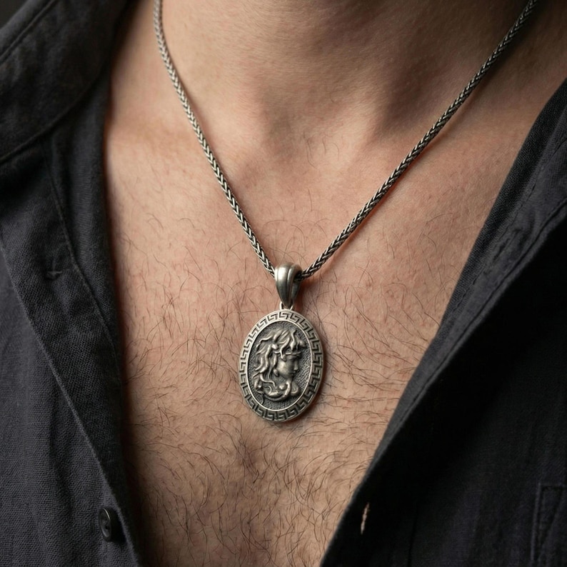 Oxidized 925 sterling silver Medusa coin pendant worn on neck, Greek key border medallion with bold mythological portrait relief