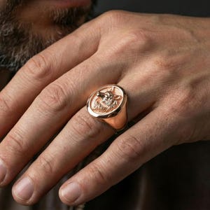 Rose gold-plated wolf signet ring worn on finger, bold alpha wolf aesthetic for confident styling