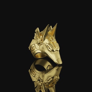 May include: A gold ring with an Anubis head design. The ring features intricate details and an ankh symbol on the head.