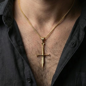 Gold plated sword necklace pendant worn on neck, close-up lifestyle shot, luxury lighting, elegant metallic highlight