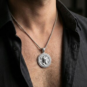Polished silver Perseus coin pendant necklace worn on the neck, clean lifestyle wear shot capturing bright shine and the detailed winged helmet relief in natural light.