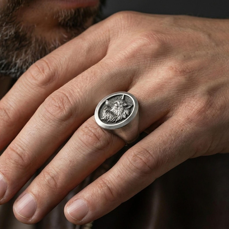 Oxidized wolf signet ring worn on finger, masculine everyday look with rugged animal totem style