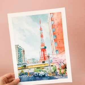 May include: Watercolour painting of a red and white tower with a blue sky and clouds in the background. There are buildings and trees in the foreground, and a street with cars and people walking.