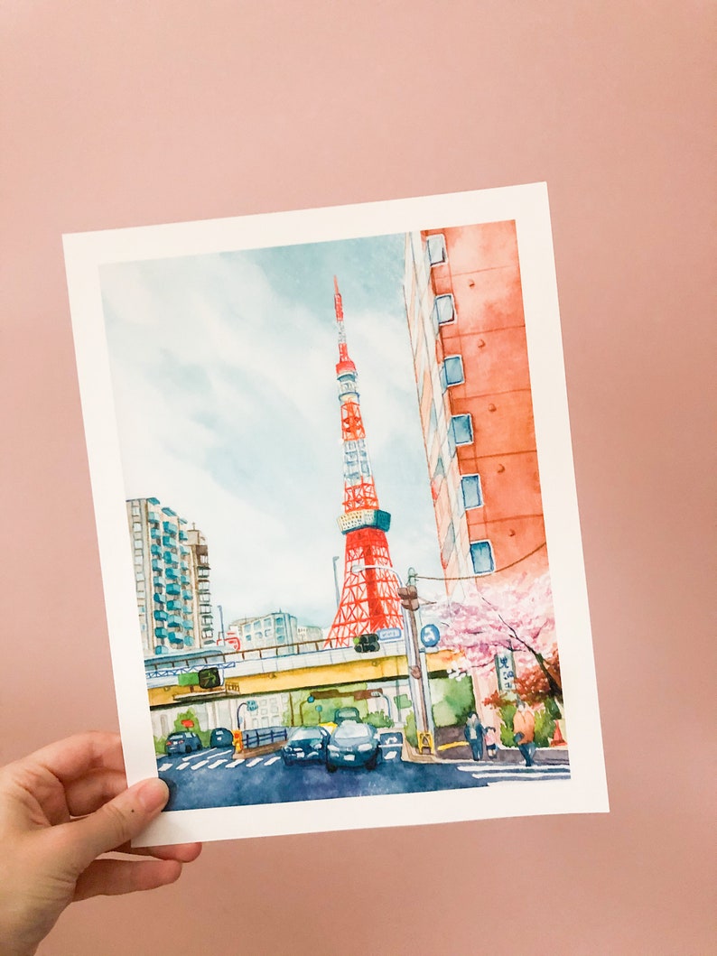 May include: Watercolour painting of a red and white tower with a blue sky and clouds in the background. There are buildings and trees in the foreground, and a street with cars and people walking.
