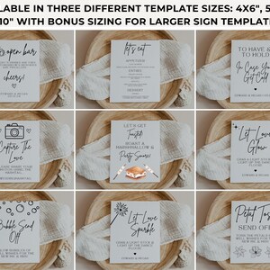 May include: A collection of wedding signage templates in various sizes. Each sign features elegant black script on a white background, with phrases like "Open Bar," "Capture the Love," and "Let Love Glow." The signs are arranged on wooden trays.