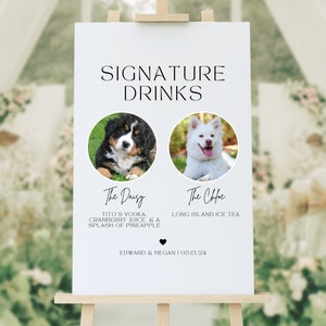 May include: A white sign on an easel with the words "SIGNATURE DRINKS" at the top. Below are two circular photos of dogs, with drink names and ingredients listed. The sign includes the names Edward & Megan and the date 05.13.24.