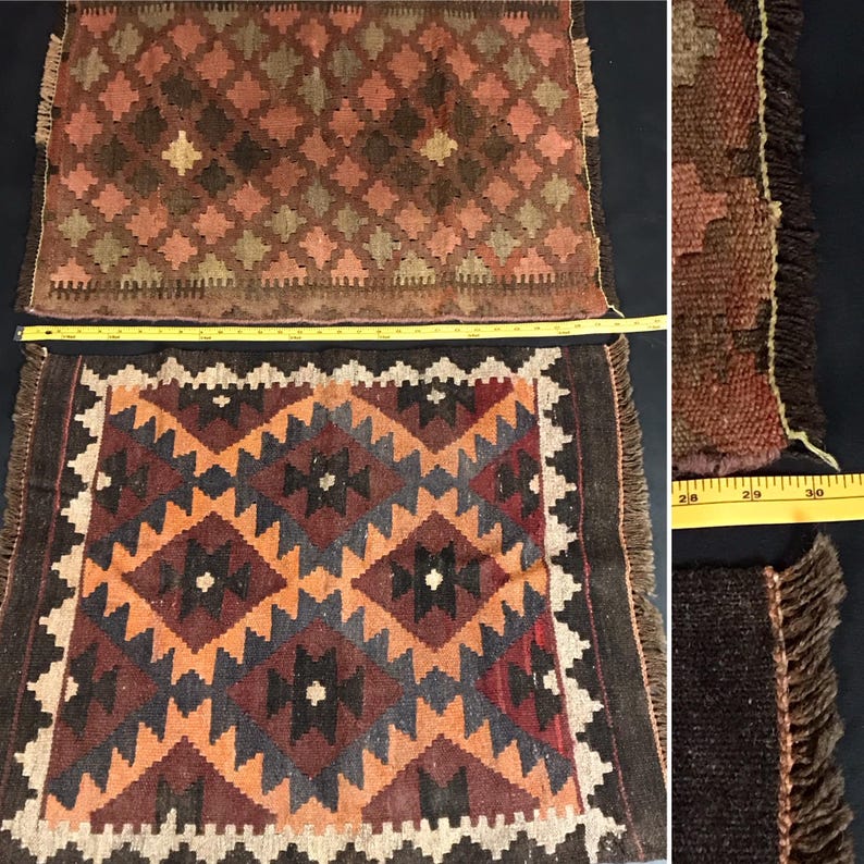 May include: Two handmade woven rugs with intricate geometric patterns in shades of red, orange, brown, black, and white. The rugs have fringe borders and are displayed on a white surface.