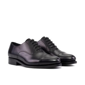 May include: A pair of black leather dress shoes with a cap toe design. The shoes have black laces and a low heel. The shoes are displayed on a white background.