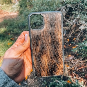 May include: A black phone case with a brown and black cowhide pattern.