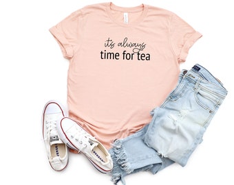 May include: A peach-colored t-shirt with the text "it's always time for tea" in black script.