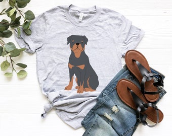 May include: A gray t-shirt with a black and brown Rottweiler dog illustration. The dog is sitting and looking at the camera.