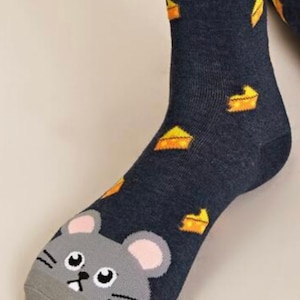 Puede incluir: Un par de calcetines de tobillo azul oscuro con una cara de rat&oacute;n gris en la punta y un patr&oacute;n de cu&ntilde;as de queso amarillo en el calcet&iacute;n.