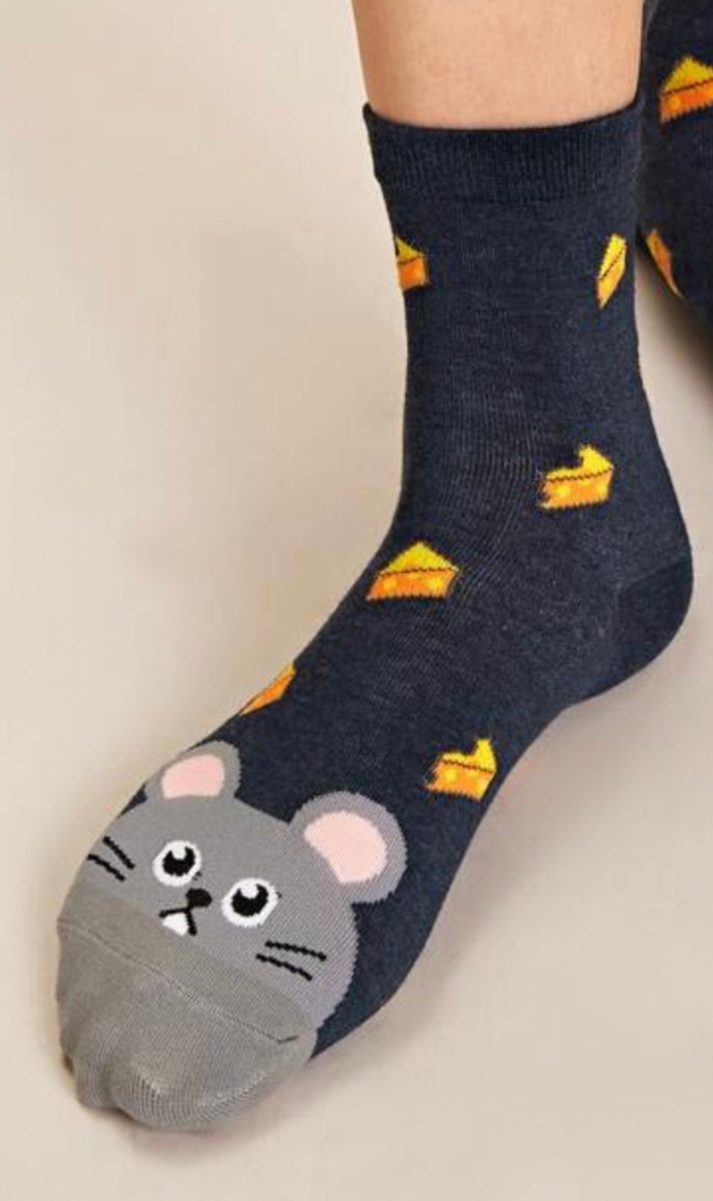 Puede incluir: Un par de calcetines de tobillo azul oscuro con una cara de rat&oacute;n gris en la punta y un patr&oacute;n de cu&ntilde;as de queso amarillo en el calcet&iacute;n.