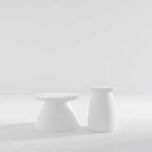 May include: Two white pedestal tables, one taller than the other, on a white background.