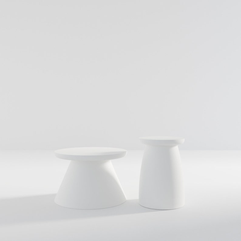 May include: Two white pedestal tables, one taller than the other, on a white background.