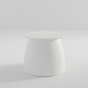 Pu&ograve; includere: Tavolo rotondo bianco con una base leggermente svasata e un piano con piccoli fori.