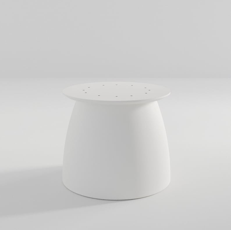 Pu&ograve; includere: Tavolo rotondo bianco con una base leggermente svasata e un piano con piccoli fori.