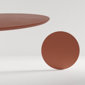 May include: Two terracotta coloured circular ceramic platforms, one larger than the other, on a white background.