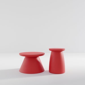 May include: Two red, round, pedestal-style tables. The table on the left is larger and has a wider base. The table on the right is smaller and has a narrower base.