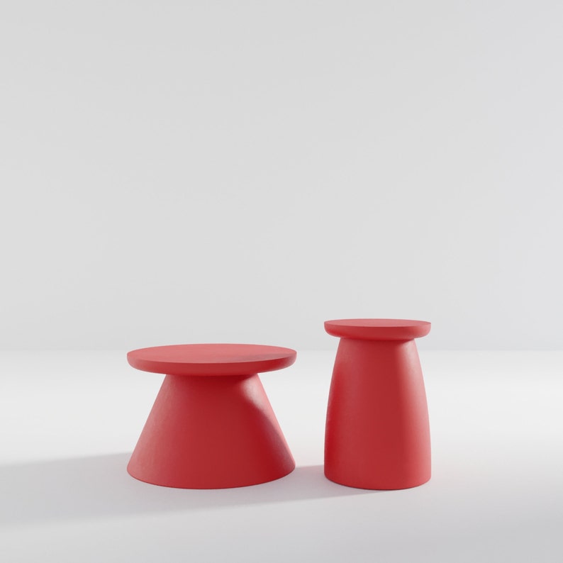 May include: Two red, round, pedestal-style tables. The table on the left is larger and has a wider base. The table on the right is smaller and has a narrower base.