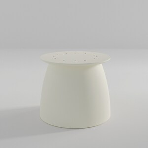 Pu&ograve; includere: Sgabello rotondo bianco con una base leggermente svasata e una parte superiore con piccoli fori.