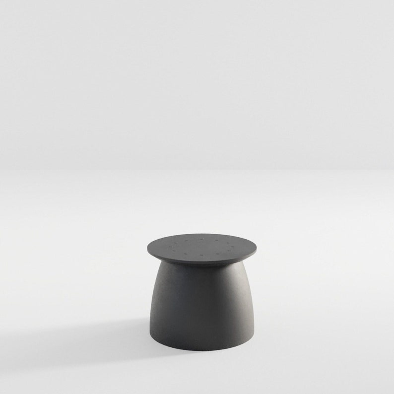 May include: A small, round, black side table with a textured surface and a circular top with small holes.