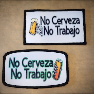 Op de afbeelding: Twee witte patches met zwarte randen, elk met een skelet hand die een biertje vasthoudt. De bovenste patch heeft de tekst "No Cerveza No Trabajo" in zwart. De onderste patch heeft de tekst "No Cerveza No Trabajo" in groen.