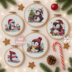 May include: A collection of five cross-stitch patterns featuring penguins in festive holiday scenes. Each design is framed in a wooden hoop and includes a penguin wearing a Santa hat and scarf, engaged in activities like singing or skiing.