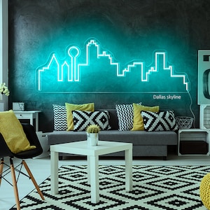 Pu&ograve; includere: Un'insegna al neon turchese raffigurante lo skyline di Dallas &egrave; montata su una parete grigio scuro. L'insegna illumina un soggiorno con un divano grigio, cuscini decorativi e un tappeto a motivi bianchi e neri. Il testo "Dallas skyline" &egrave; sotto.
